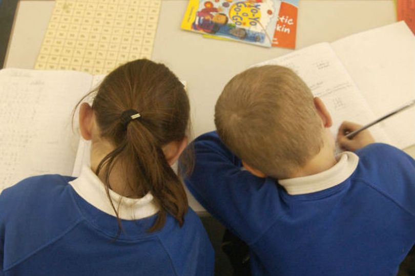 a photo of two children doing school work in text books
