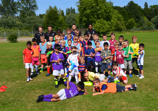 children in football kits gathered outside