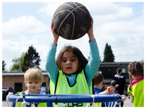 a child about to place a basket ball into a basket