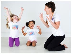 two young children and a yogabugs coach pretending to be lions