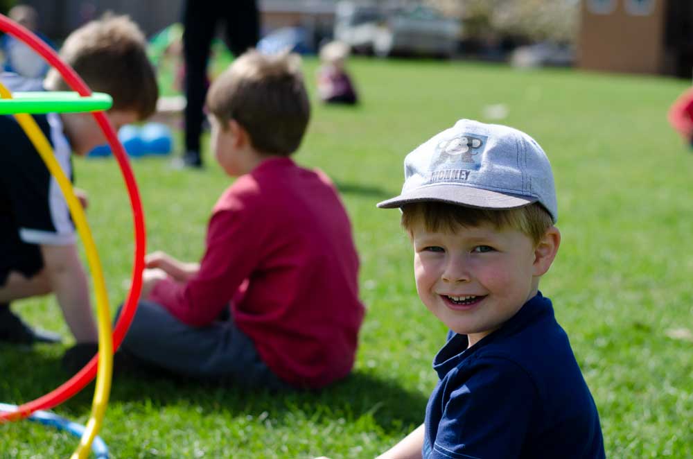 a child smiling outside in the sunshine