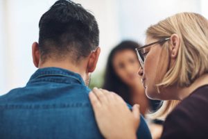 Shot of a wife consoling her husband during a counseling session with a therapist