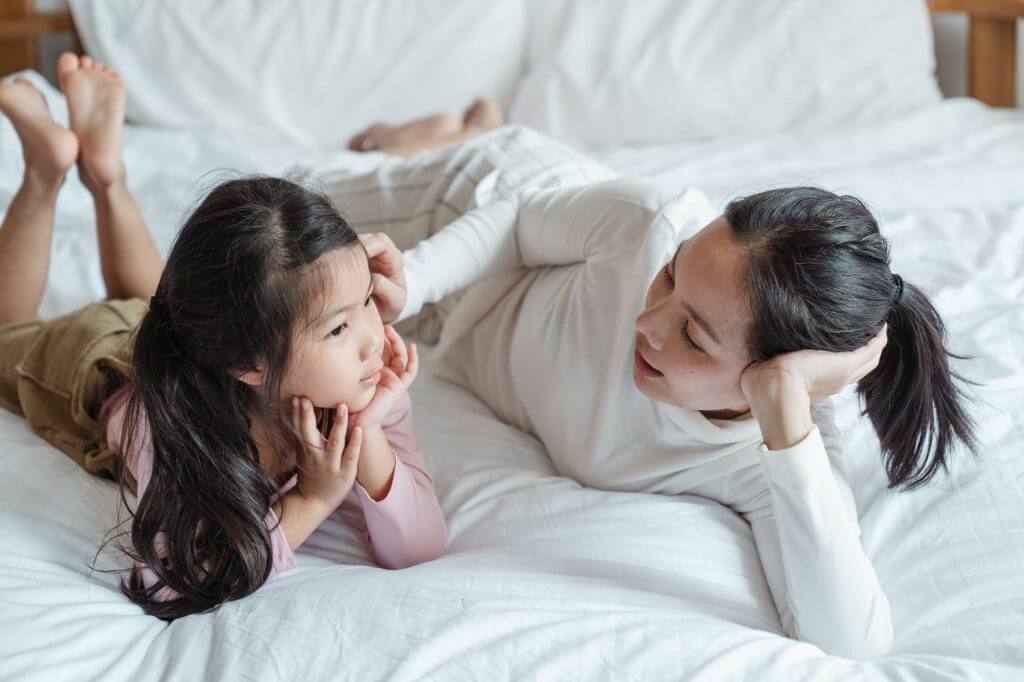 image of a mother and child on a bed talking