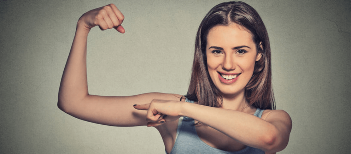 a girl making a muscle and pointing at it