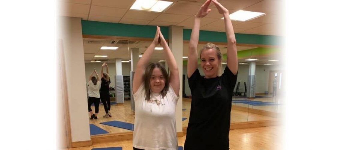 image of a yogabugs coach and an SEN child smiling and doing a yoga pose