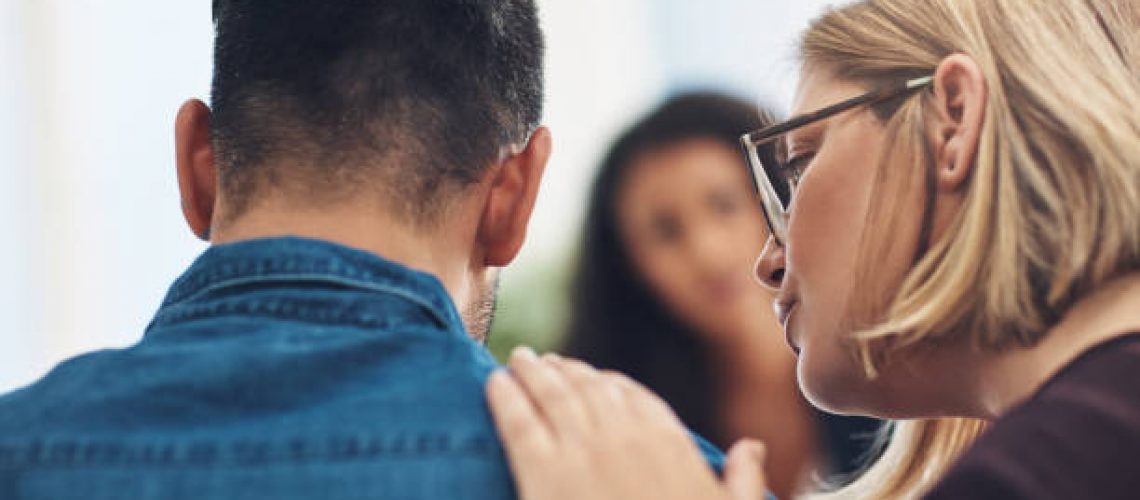 Shot of a wife consoling her husband during a counseling session with a therapist