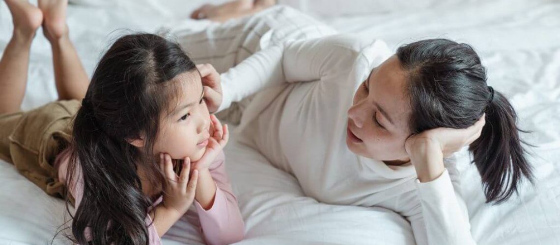 image of a mother and child on a bed talking